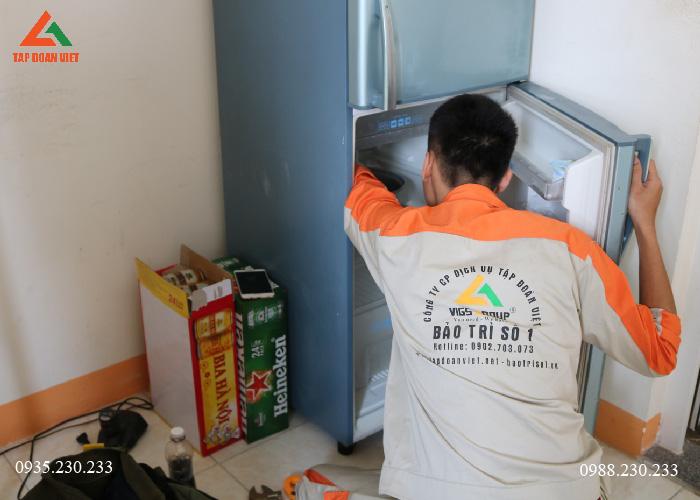 Kỹ thuật viên dọn đồ ở ngăn mát tủ lạnh để chuẩn bị cho quá trình vệ sinh tủ lạnh